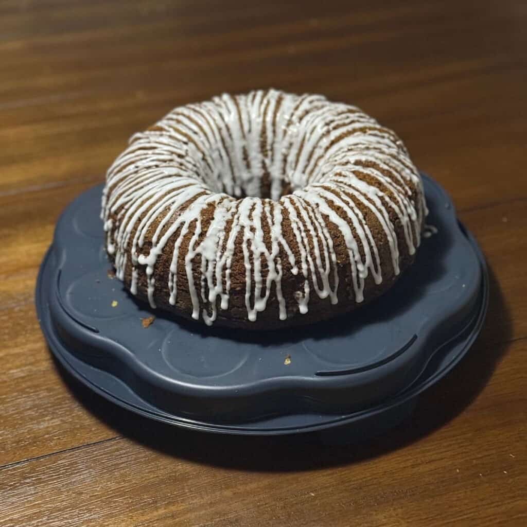 A glazed pumpkin cake on a cake platter.